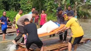Kapolsek Beduai Turun Tangan Angkut Jenazah Warga yang Terjebak Banjir di Kalbar