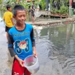 Banjir Pegangsaan Dua: Anak-Anak Ceria Menangkap Ikan untuk Lauk Pauk