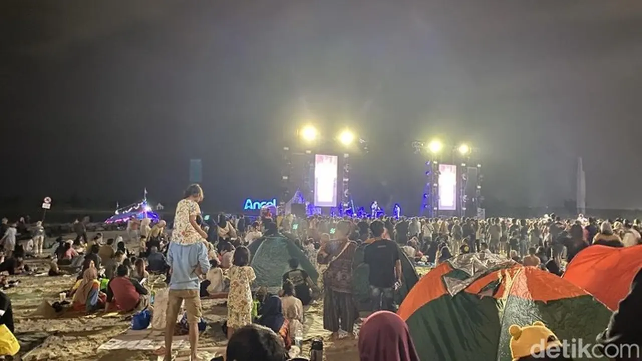 Hujan Tak Surutkan Semangat Warga Nikmati Konser Dewa 19 di Ancol Malam Tahun Baru