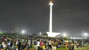Hujan Tak Surutkan Warga, Yayat dari Berau Bertahan di Monas Sambut Tahun Baru
