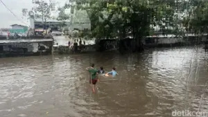 Banjir 30-50 Cm Genangi Jalan Daan Mogot, Anak-anak Asyik Berenang di Tengah Kemacetan